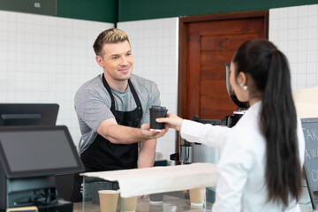 Fototapeta premium male barista giving a cup of coffee to customer in cafe or coffee shop