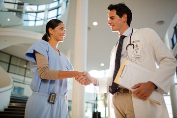 Doctor and nurse handshaking in hospital