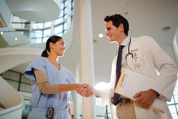 Doctor and nurse handshaking in hospital