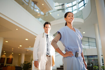 Portrait of smiling doctor and nurse in hospital atrium