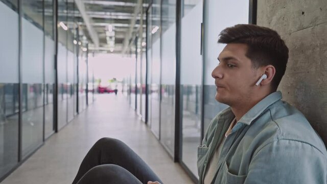 Stressed male employee thinking of problem, sitting on the floor, failed startup