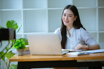 Portrait of Beautiful businesswoman sitting at desk and working with laptop computer.