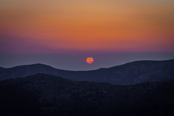 El sol rasgado por las nubes al atardecer