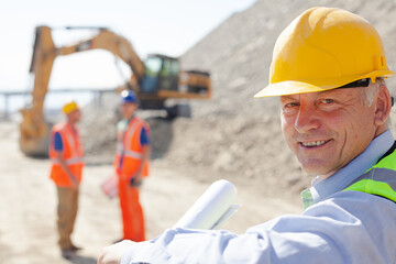 Businessman in hard hat smiling in quarry