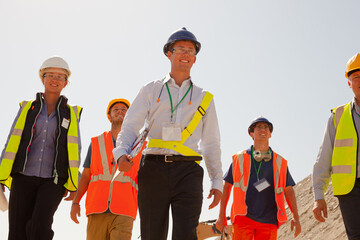 Businessman in hard hat smiling in quarry