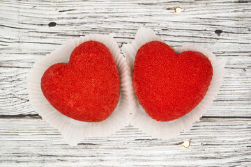 A bright red heart-shaped cakes on a wooden background