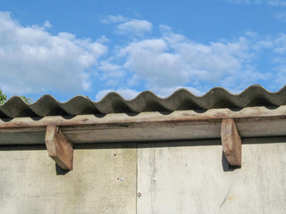 Attic of an old house covered with ribbed slate and blue sky