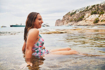 Young cheerful spanish woman laughing in beach