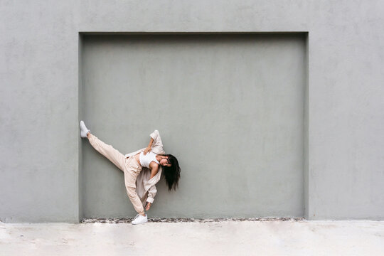 Graceful dancer performing near wall in city street
