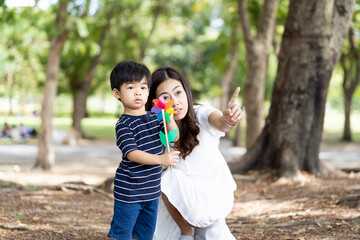 Happy Asian family playing together outdoor. Mother and little son relaxing on holiday in the the park. Mom spending time with little son on vacation. Happy family and holiday