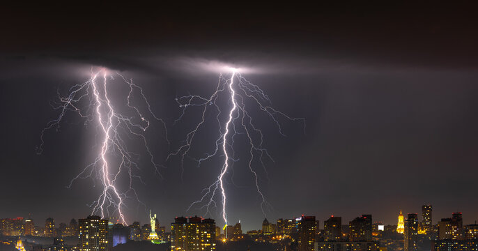 Lightning storm over the city at the summer heavy rain. Dramatic, breathtaking atmospheric natural phenomenon. Kyiv, Ukraine.