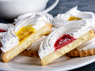 Half cookies covered with meringue and marmalade on a plate