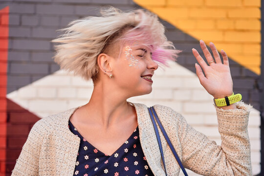 Content informal woman throwing dyed hair in city