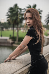 Close-up portrait of beautiful asian girl in black dress. Wind in her hair. Looking at camera with copy space. Lovely Vietnamese woman. High quality