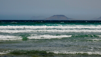 Starker Wellengang an der Atlantikküste, stürmische hohe Wellen am Strand bei schönem Wetter