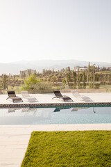 Fototapeta na wymiar Luxury lap pool with tree and mountains in background