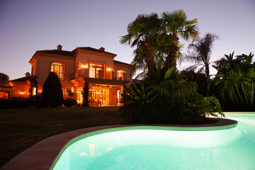 Luxury swimming pool and villa at dusk