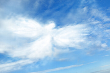 Fototapeta na wymiar Silhouette of angel made of clouds in blue sky