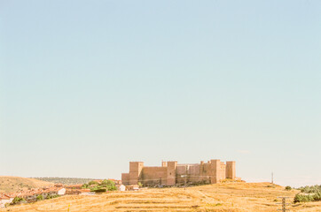 view of the old medieval town in country Spain. View on old castle in the pastel blue sky during a hot day of summer holiday.