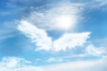 Silhouette of angel's wings made of clouds in blue sky - Powered by Adobe