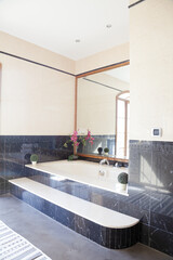 Black marble surrounding bathtub in luxury bathroom