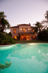 Luxury swimming pool and villa at dusk