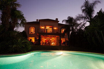 Luxury swimming pool and villa at dusk