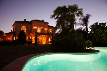 Luxury swimming pool and villa at dusk