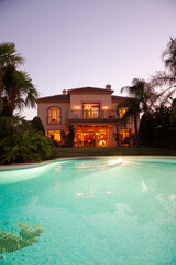 Luxury swimming pool and villa at dusk