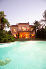 Luxury swimming pool and villa at dusk