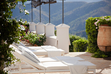 Lounge chairs and umbrellas on balcony of luxury hotel