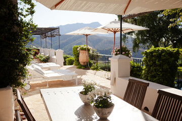 Obraz premium Lounge chairs and umbrellas on balcony of luxury hotel