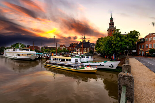 Leer, east frisia. View from Leda river on City Hall in Dutch Renaissance style , old Weigh House in Dutch classical Baroque style, Tourist Harbor and Bridge of Erich vom Bruch at sunset