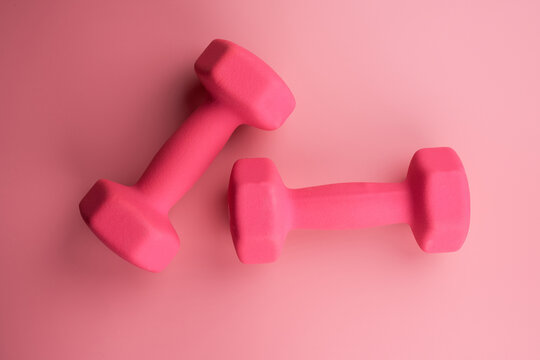 Conceptual fitness and healthy sport background with pink dumbbell