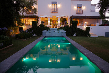 Fototapeta na wymiar Luxury swimming pool and villa illuminated at night