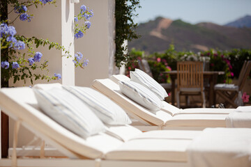 Lounge chairs and towels at poolside of luxury hotel