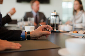 Close up of businessman's hand sitting in meeting