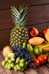 Mix of fresh juicy colorful exotic tropical fruits on wooden background