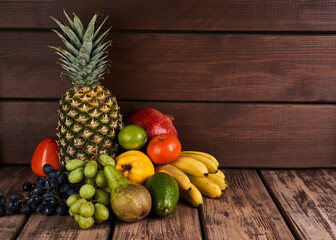 Mix of fresh juicy colorful exotic tropical fruits on wooden background