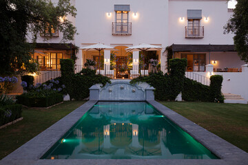 Luxury swimming pool and villa illuminated at night