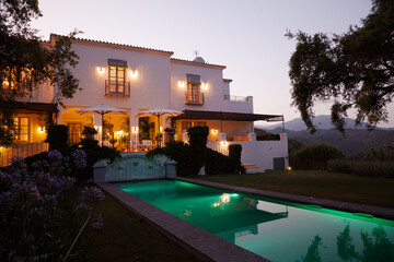 Luxury swimming pool and villa illuminated at night