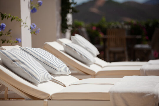 Lounge chairs and towels at poolside of luxury hotel