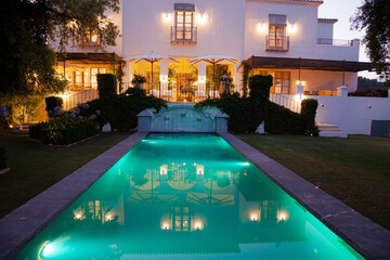 Luxury swimming pool and villa illuminated at night