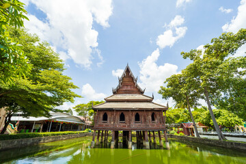 Fototapeta na wymiar Beautiful of Tripitaka Storage Tower.Thai wooden temple architecture in the middle of the pond at wat Thung Si Muang in Ubon Ratchathani province, Thailand, ASIA.