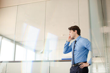Businessman talking on cell phone in office