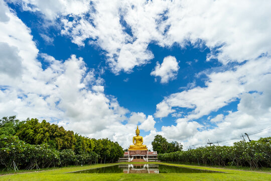 Beautiful Big Golden Buddha statue under blue sky background, khueang nai District, Ubon Ratchathani province, Thailand.