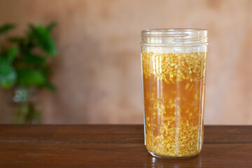 A Glass of Ginger Bug Starter for Naturally Carbonated Sodas Made  With Sugar, Ginger and Water on Wooden Table