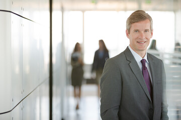 Businessman smiling in office hallway