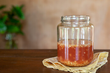 A Jar of  Wild Ginger Bug Starter for Naturally Carbonated Sodas Made  With Sugar, Ginger and Water on Wooden Table