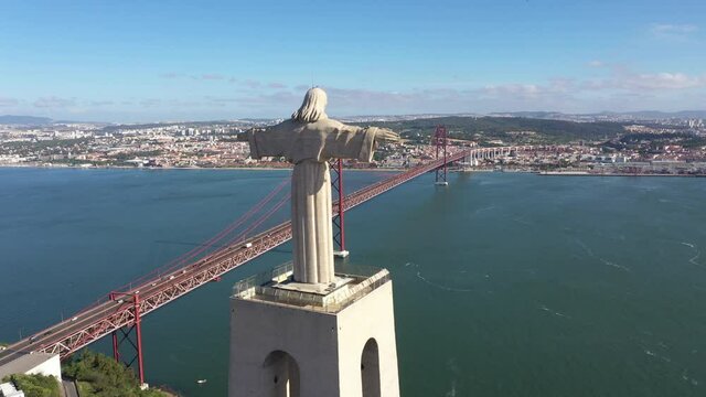 Flying past Christ the King statue, towards the red suspension bridge 'Ponte 25 de Abril', tourism and travel Lisbon, Portugal

